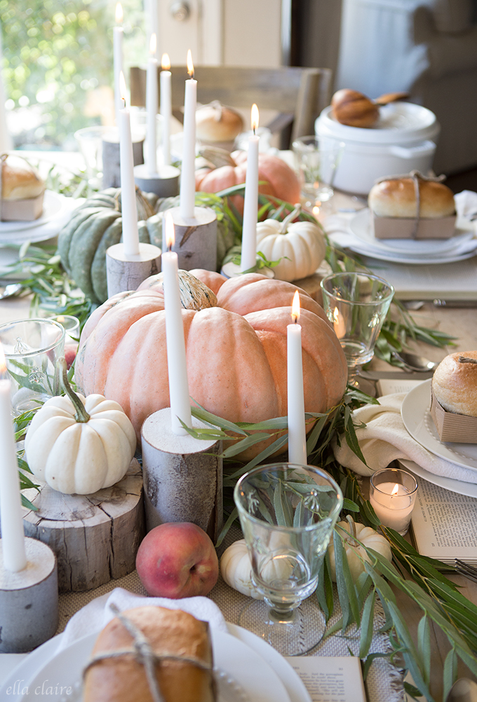 If in doubt when decorating your fall table, the answer is pumpkins on pumpkins. This table features pastel orange, white, and green pumpkins of various sizes and shapes. Use tree stumps to add levels, and mix in candles for an element of warmth.
