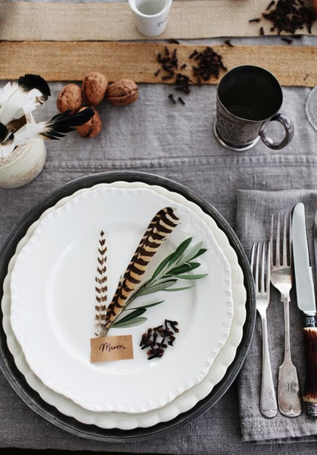 In keeping with the theme of nature, consider pairing together a faux feather and a piece of greenery for a simple, delicate plate detail.