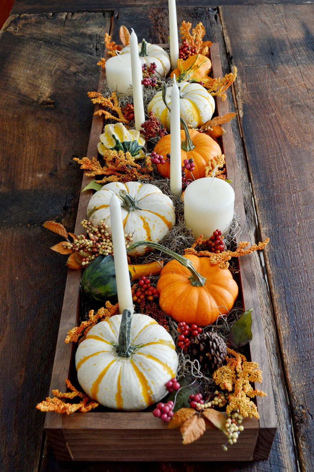 Fall table ideas: If you’re looking for more structure in your table runner, using a simple wooden box is the perfect way to display your fall decor. Fill it with moss, greenery, candles, pumpkins, pinecones and whatever other hodgepodge of autumn items you have on hand.