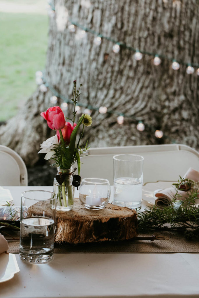 Rehearsal Dinner Centerpiece idea: Fresh flowers and tulips in a small jar with votive candle and tree stump. / theanastasiaco.com