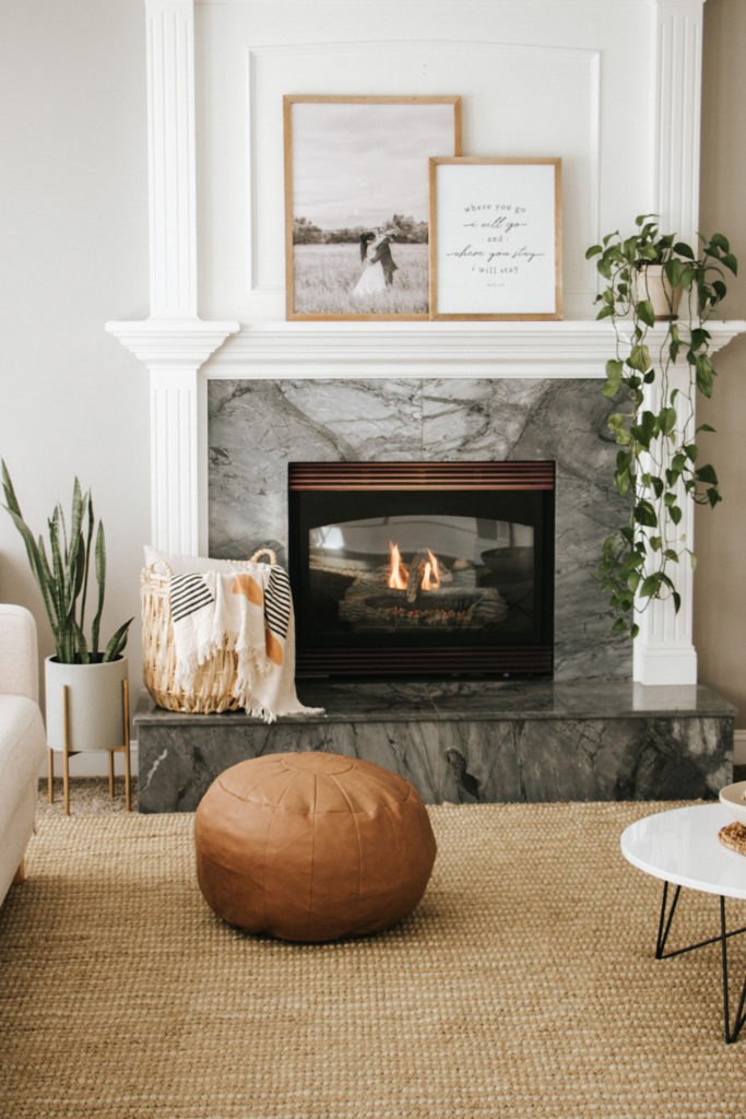 White modern marble mantel with layered pictures and plants | The Anastasia Co