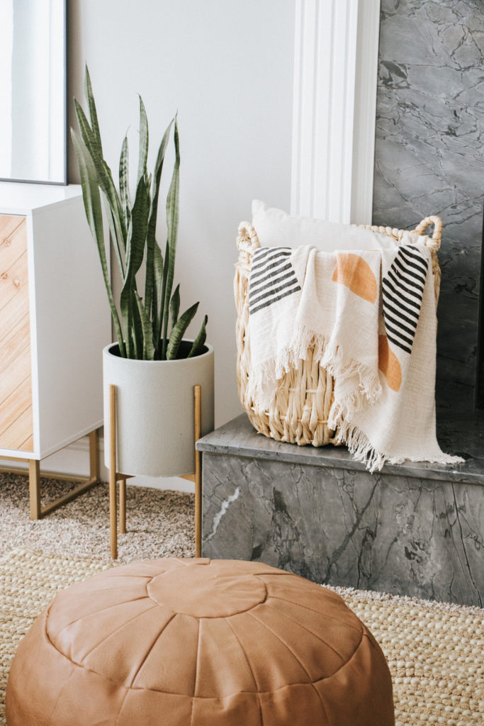 Snake plant with wicker basket and brown pouf | Modern boho living room | The Anastasia Co